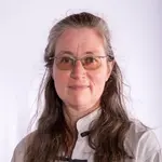 Eine Frau in traditioneller Kampfkunstkleidung repräsentiert die Turngemeinde Landshut mit ruhiger Ausstrahlung.