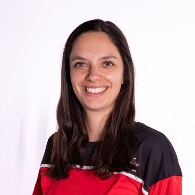 Eine Frau in rotem Sporttrikot lächelt in die Kamera, repräsentiert die Turngemeinde Landshut.