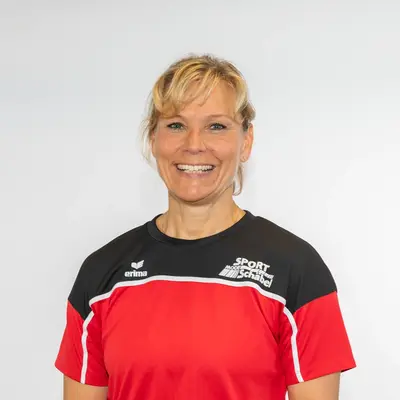 Eine Frau in einem roten KiSS-Pullover lächelt und repräsentiert stolz den Sportverein Turngemeinde Landshut.