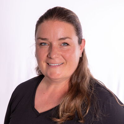 Eine Frau in schwarzem Oberteil lächelt freundlich in die Kamera, passend zur sportlichen Atmosphäre der Turngemeinde Landshut.