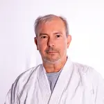 Ein Mann in einem weißen Kampfsportanzug repräsentiert die Turngemeinde Landshut mit entschlossenem Ausdruck.