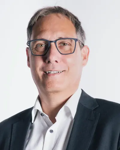 3. Vorsitzender Christian Temporale  im Anzug lächelt in die Kamera, möglicherweise ein Mitglied des Sportvereins Turngemeinde Landshut.