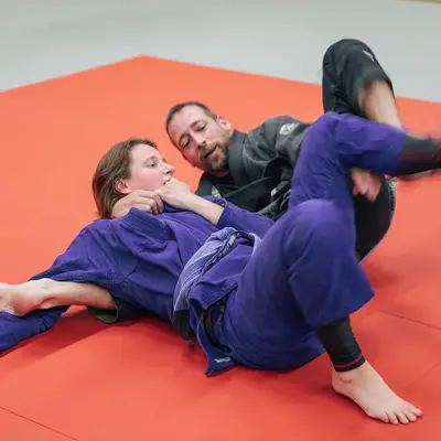 Zwei Personen trainieren Jiu-Jitsu auf einer Matte im Sportverein der Turngemeinde Landshut.