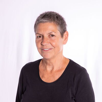 Eine Frau in schwarzem Shirt lächelt freundlich in die Kamera, während sie für die Turngemeinde Landshut posiert.