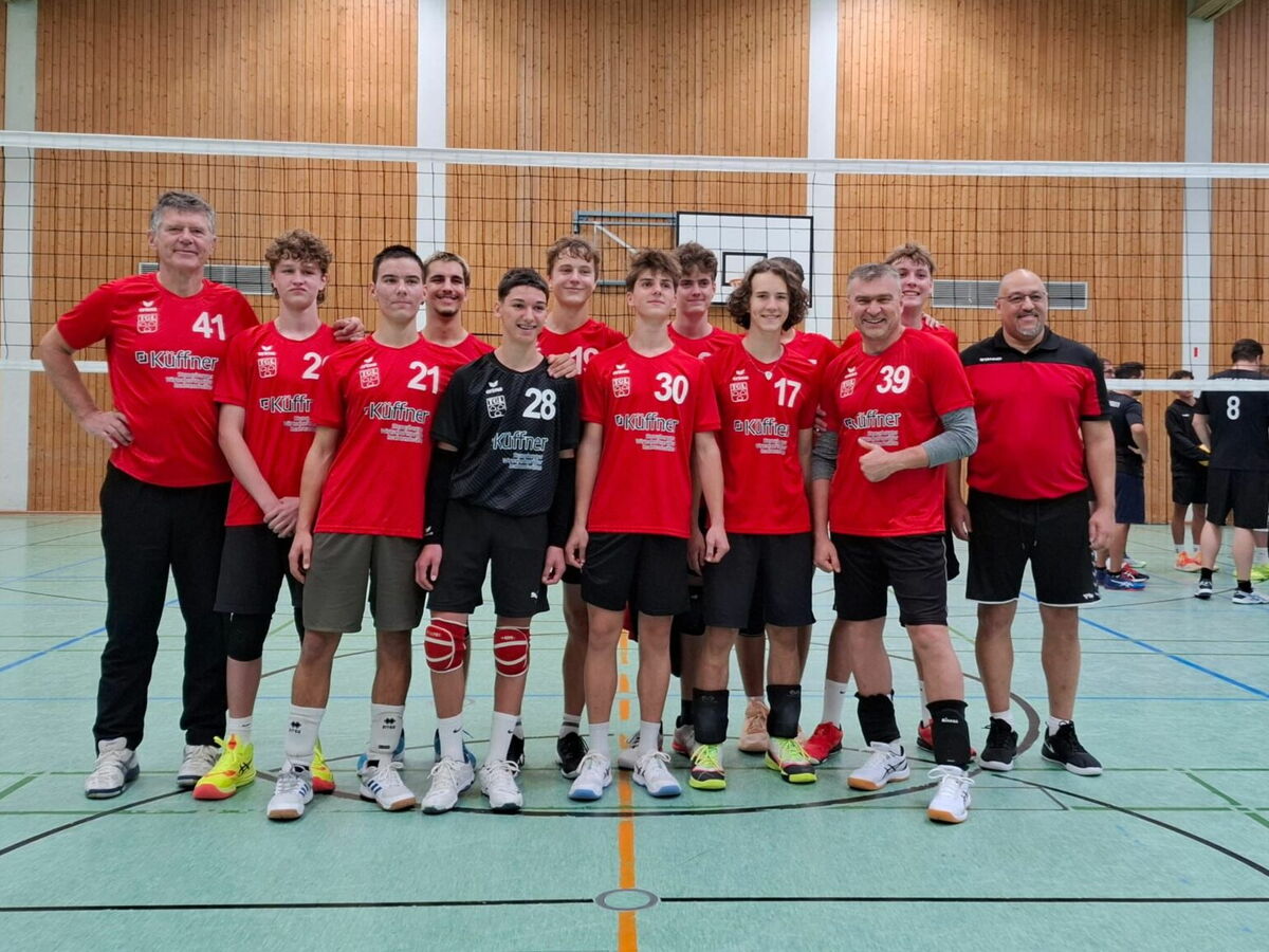 Vier Männer in einheitlichen Sporttrikots posieren lächelnd in einer Turnhalle des Turnvereins Landshut.
