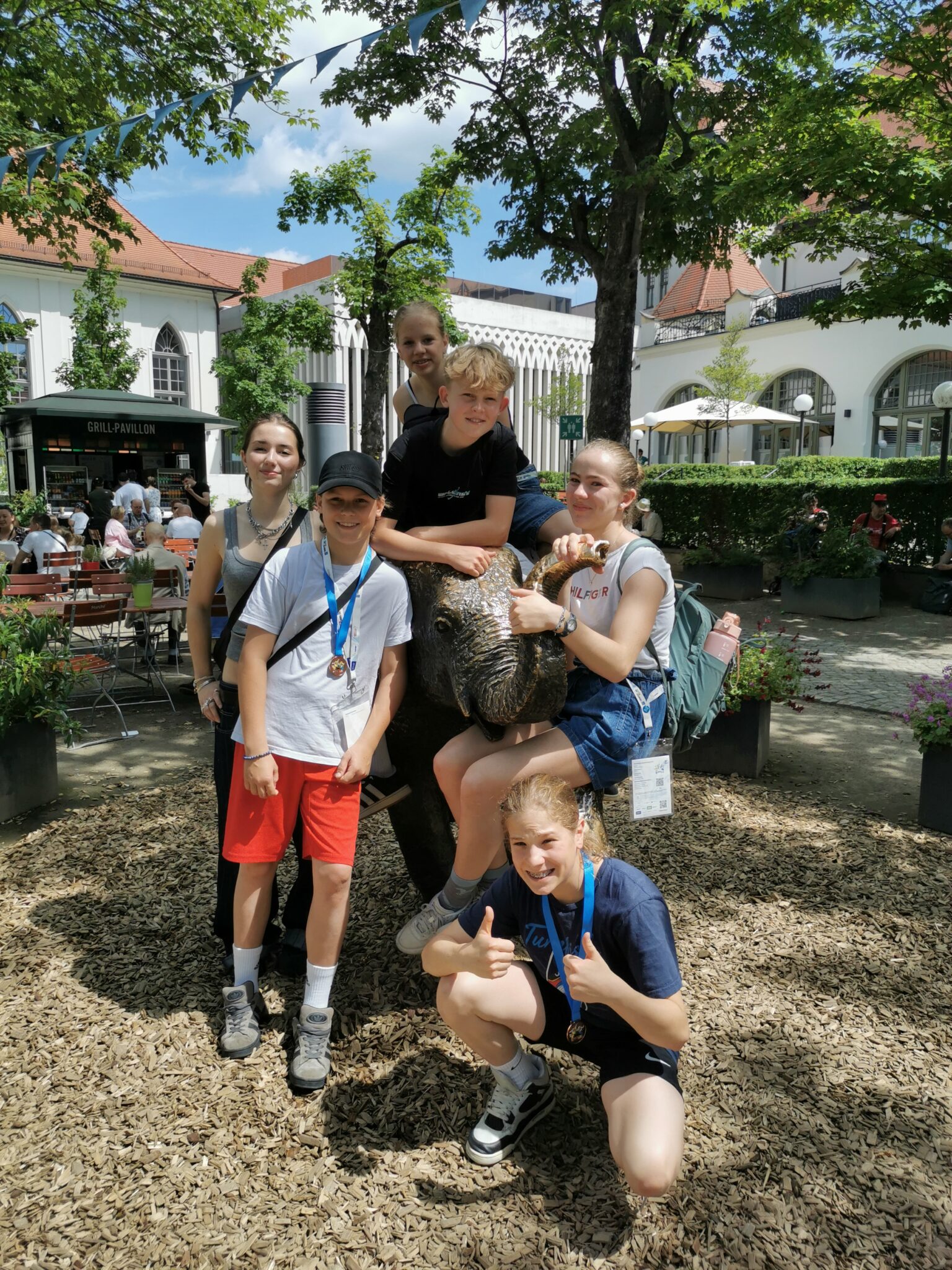 Eine Gruppe Jugendlicher genießt tierischen Spaß im Zoo, passend zu einem Vereinsausflug von Turngemeinde Landshut.